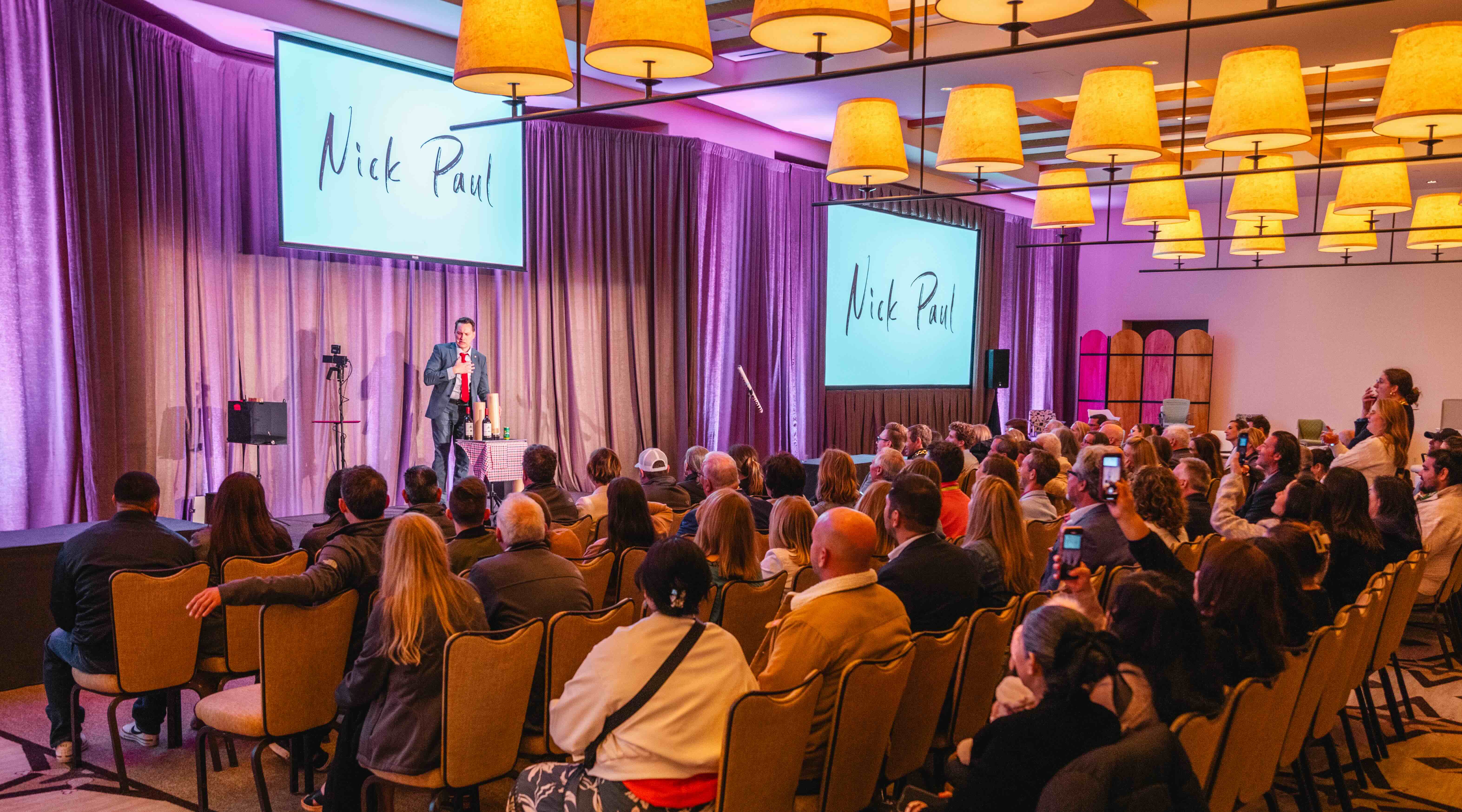 Nick Paul on stage in front of a full corporate audience at a Michigan company event